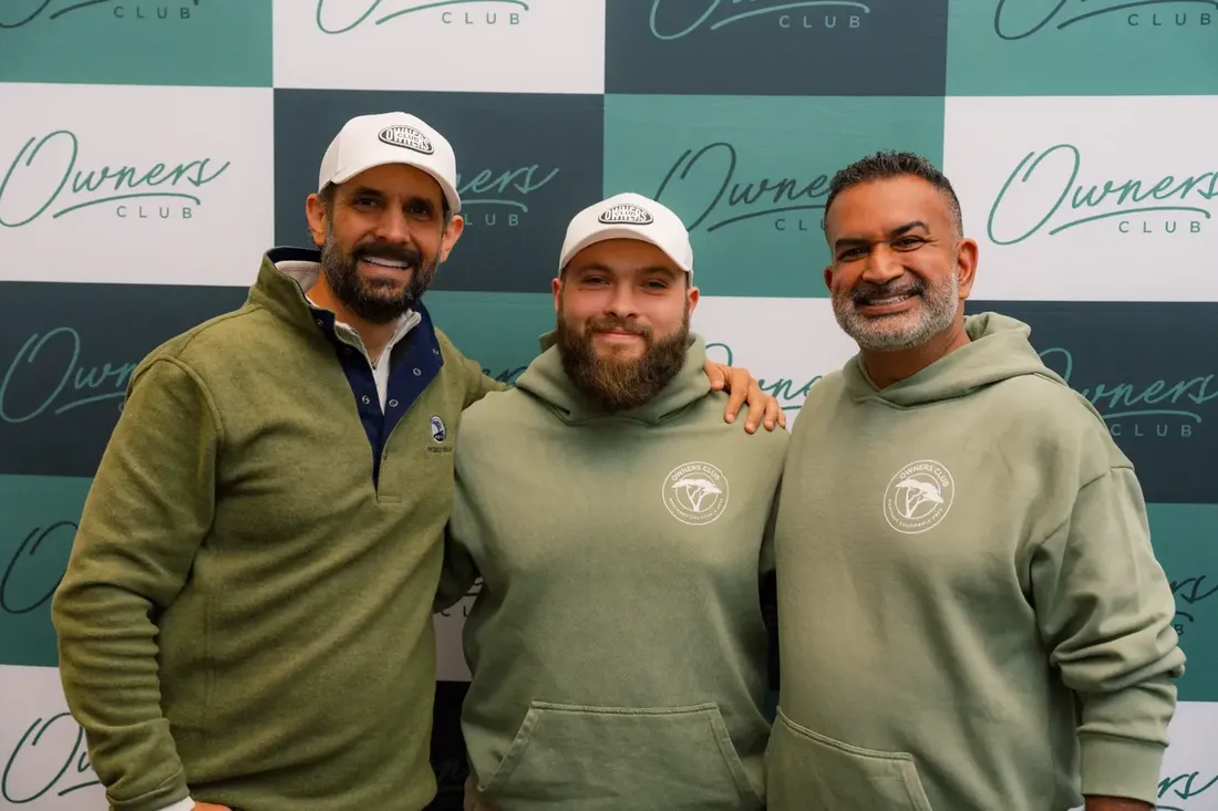 Noah Armstrong with Pace Morby and Jamil Damji in front of an Owners Club backdrop.
